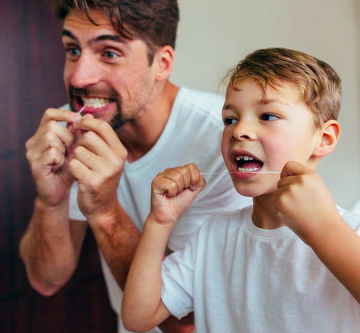 Famiglia che usa filo interdentale